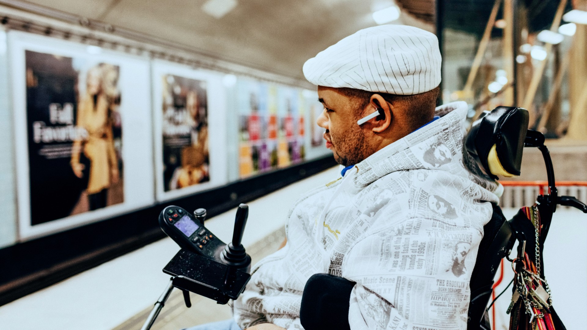 Een man in een gemotoriseerde rolstoel wacht op de metro bij het metrostation